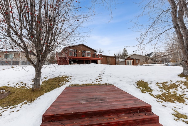 yard layered in snow featuring a wooden deck