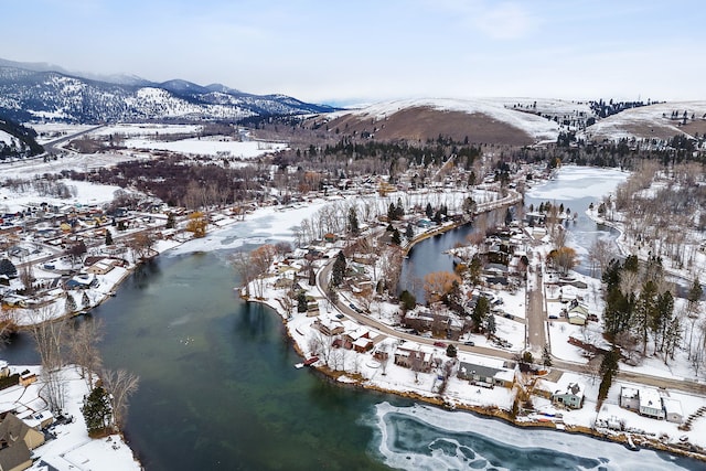 snowy aerial view with a water and mountain view