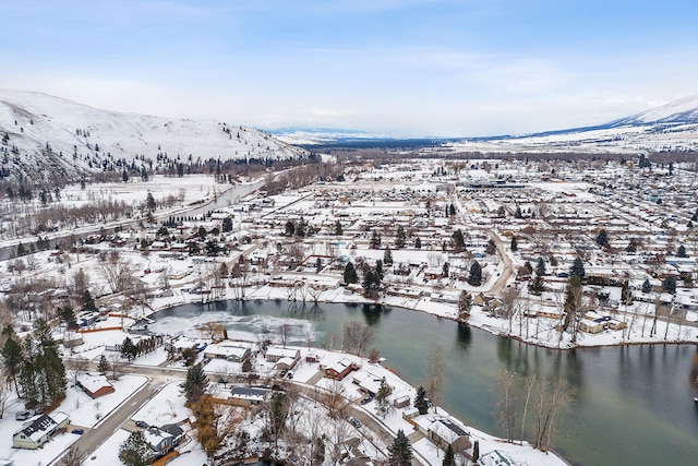 snowy aerial view with a water and mountain view