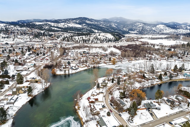 snowy aerial view with a water and mountain view