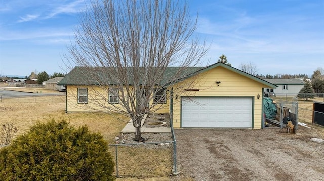 ranch-style home featuring driveway and fence