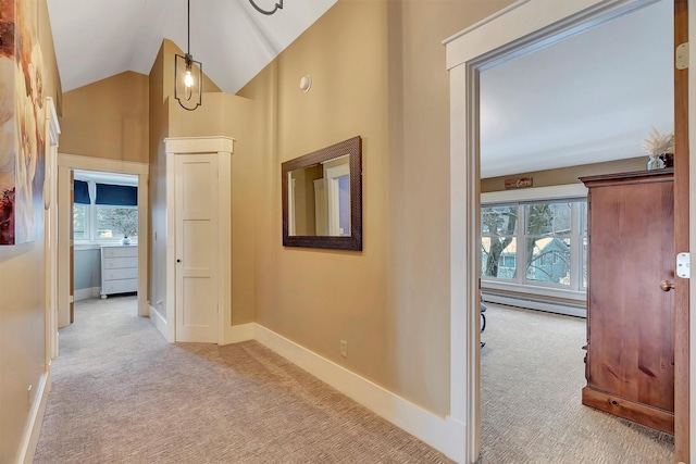 hallway featuring light colored carpet, a baseboard radiator, and vaulted ceiling