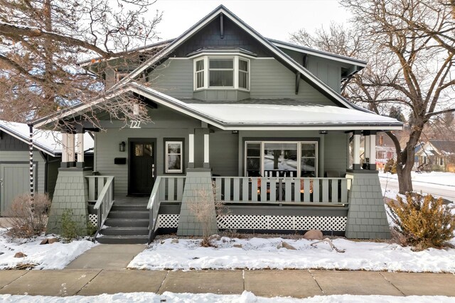 snow covered deck featuring covered porch