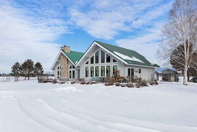 snow covered rear of property with a wooden deck