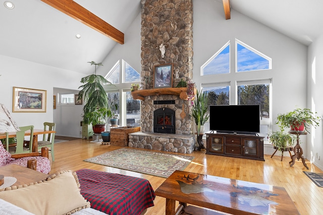 living room with a fireplace, light hardwood / wood-style floors, beamed ceiling, and high vaulted ceiling