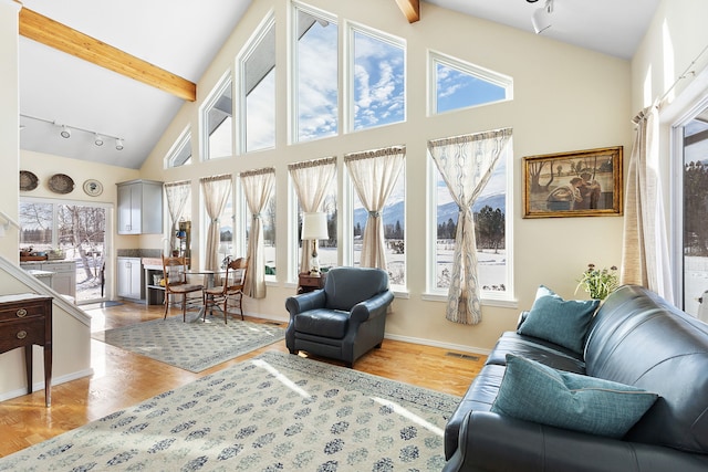 interior space with rail lighting, hardwood / wood-style floors, beam ceiling, and high vaulted ceiling