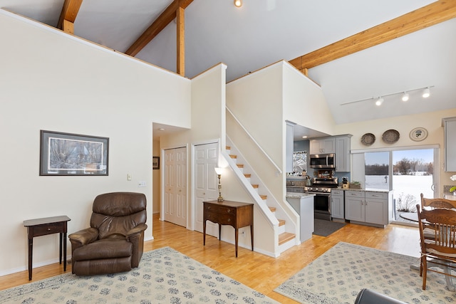 interior space featuring hardwood / wood-style flooring, high vaulted ceiling, and beam ceiling