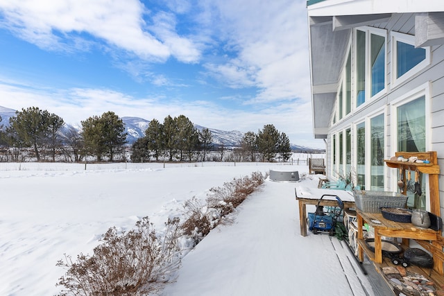 yard covered in snow featuring a mountain view