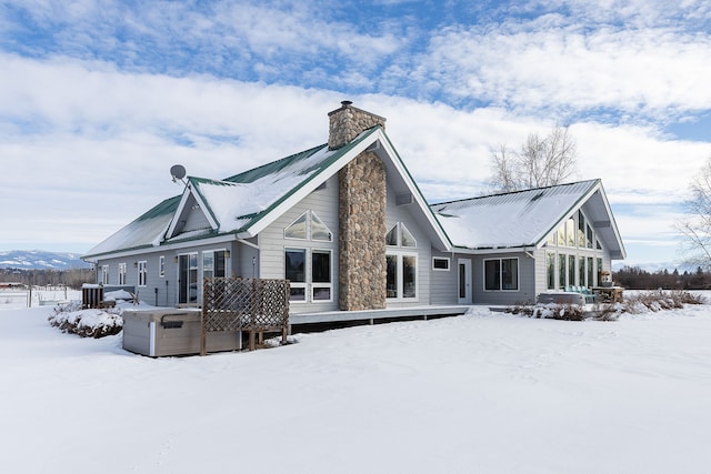 snow covered rear of property with a mountain view