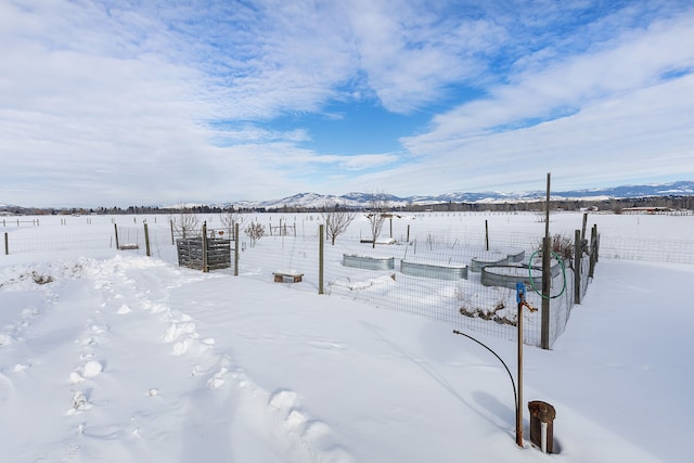 yard layered in snow featuring a mountain view and a rural view