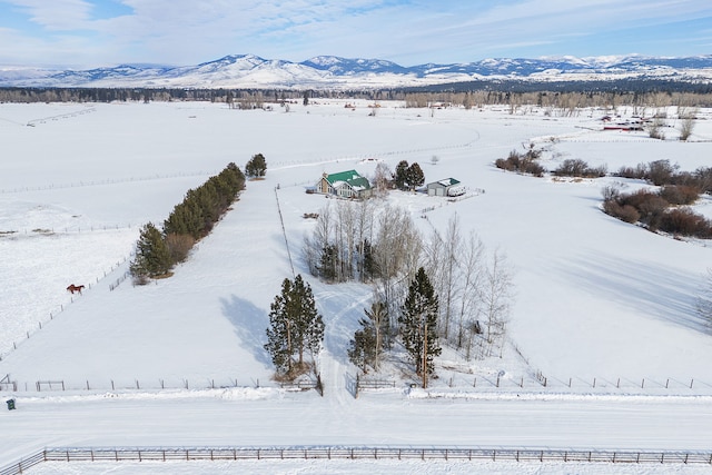 snowy aerial view featuring a mountain view and a rural view