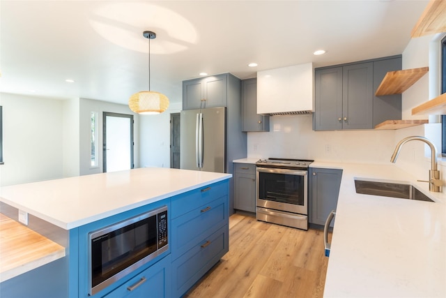 230 Fox Farm Dr, Whitefish, MT 59937 - kitchen featuring appliances with stainless steel finishes, open shelves, light countertops, light wood-type flooring, and hanging light fixtures