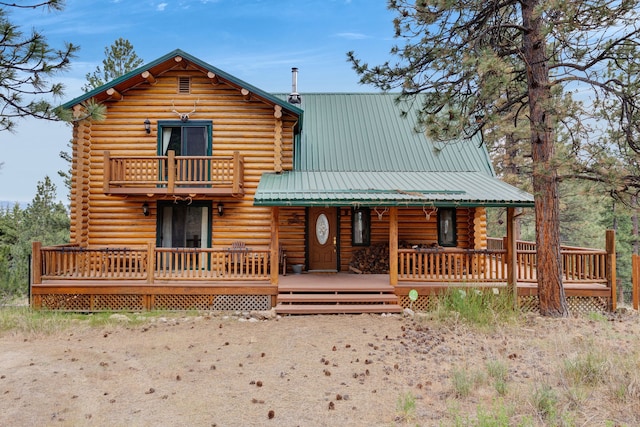 2122 Lightning Draw Trl, Victor, MT 59875 - view of front of home with log siding, a balcony, and metal roof