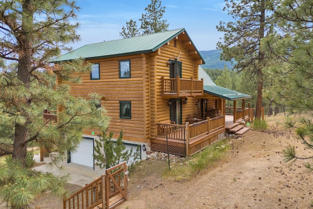 2122 Lightning Draw Trl, Victor, MT 59875 - view of side of property featuring driveway, a garage, log siding, and metal roof