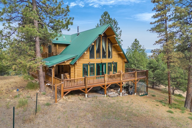 2122 Lightning Draw Trl, Victor, MT 59875 - back of house featuring log exterior, a wooden deck, and metal roof