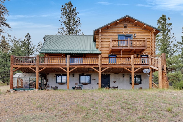2122 Lightning Draw Trl, Victor, MT 59875 - back of property with log exterior, a deck, and metal roof