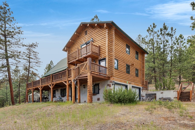 2122 Lightning Draw Trl, Victor, MT 59875 - rear view of property featuring a balcony, an attached garage, and a deck