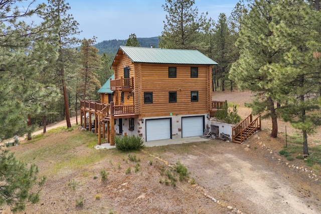 2122 Lightning Draw Trl, Victor, MT 59875 - view of front of property featuring driveway, log siding, stairway, a wooden deck, and a garage