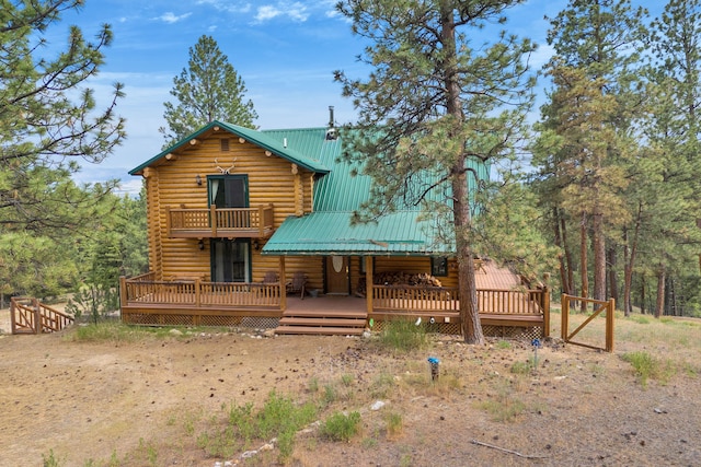 2122 Lightning Draw Trl, Victor, MT 59875 - rear view of house featuring log siding, a balcony, a wooden deck, and metal roof