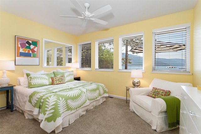 carpeted bedroom with ceiling fan and multiple windows