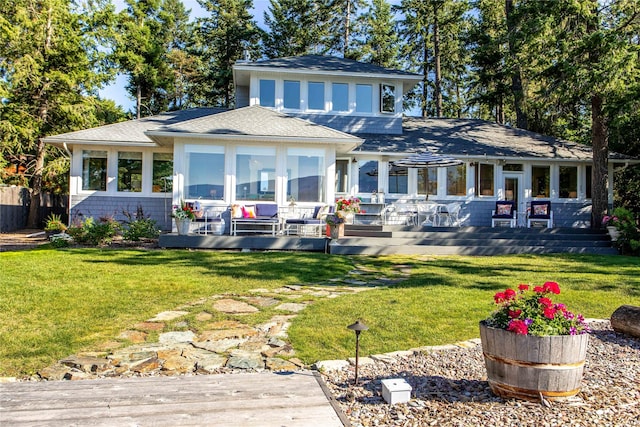 back of property with a lawn, a sunroom, and a wooden deck