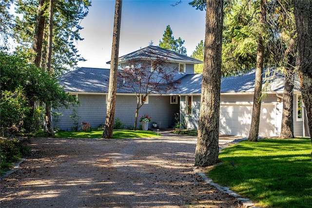 33191 Lakeshore Dr, Bigfork, MT 59911 - view of front of property featuring an attached garage, driveway, a front yard, and roof with shingles