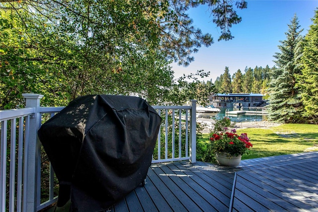 wooden deck featuring a grill and a yard