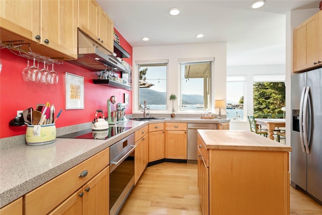 33191 Lakeshore Dr, Bigfork, MT 59911 - kitchen with appliances with stainless steel finishes, butcher block counters, light brown cabinetry, light wood-style floors, and under cabinet range hood