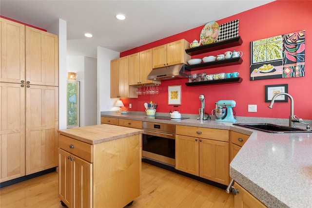 kitchen featuring sink, stainless steel oven, a center island, and light hardwood / wood-style floors