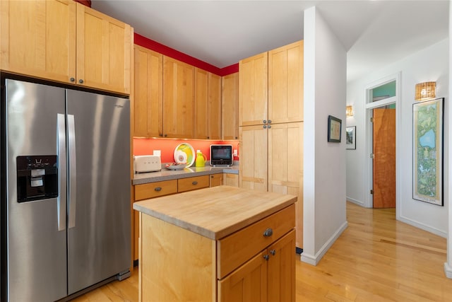 kitchen with a kitchen island, light hardwood / wood-style flooring, stainless steel fridge with ice dispenser, and light brown cabinetry