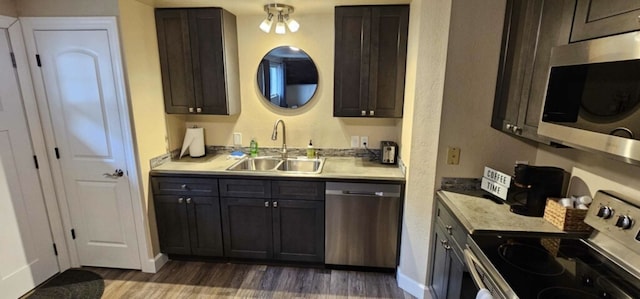 kitchen with sink, dark brown cabinetry, appliances with stainless steel finishes, and dark hardwood / wood-style flooring