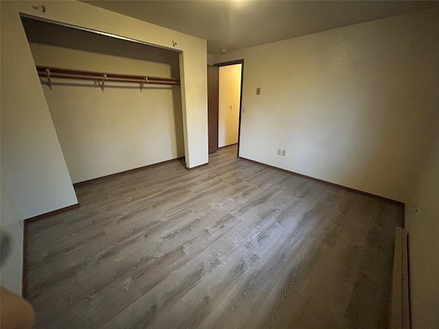 unfurnished bedroom with a closet and light hardwood / wood-style floors