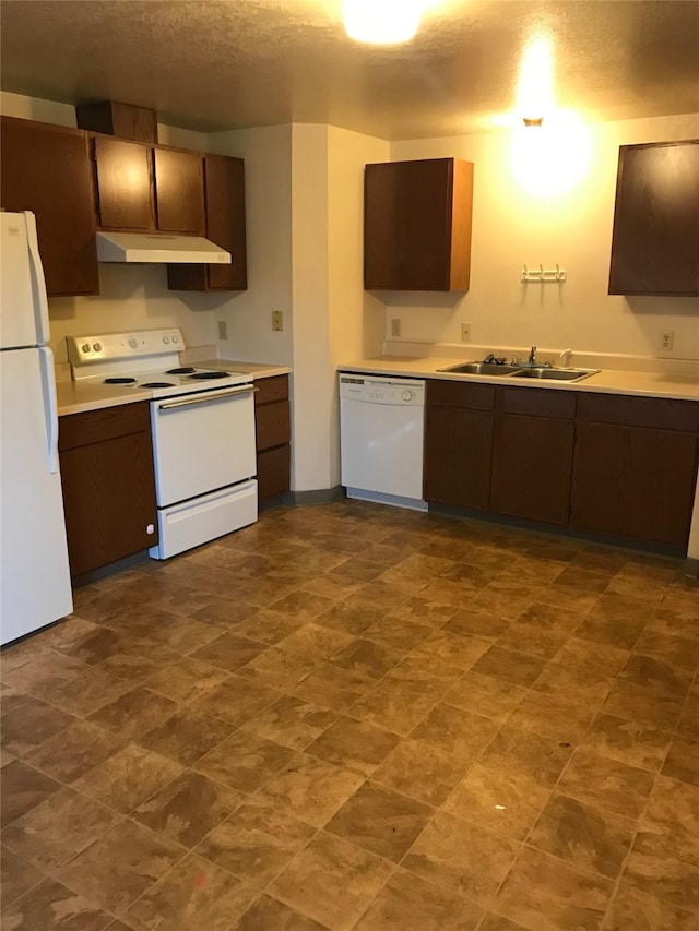 kitchen featuring sink, dark brown cabinetry, and white appliances