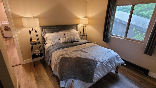 bedroom with wood-type flooring and washer / clothes dryer