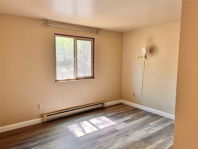 unfurnished room with baseboard heating, hardwood / wood-style floors, and a textured ceiling