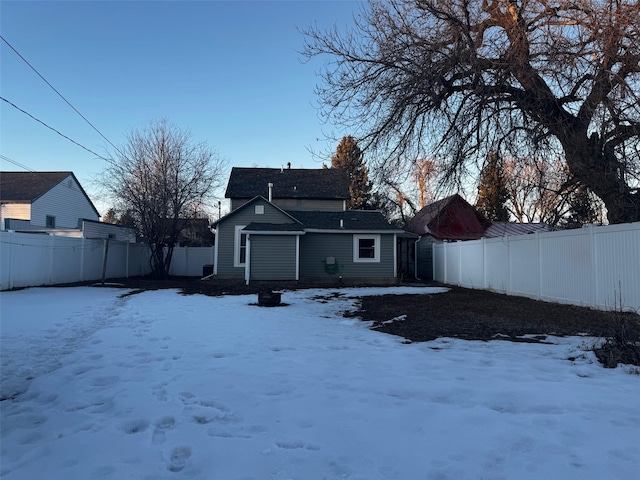 view of snow covered rear of property