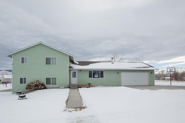 snow covered property featuring a garage