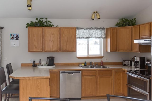 kitchen with a breakfast bar, appliances with stainless steel finishes, kitchen peninsula, and sink