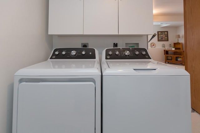 washroom with washing machine and dryer and cabinets