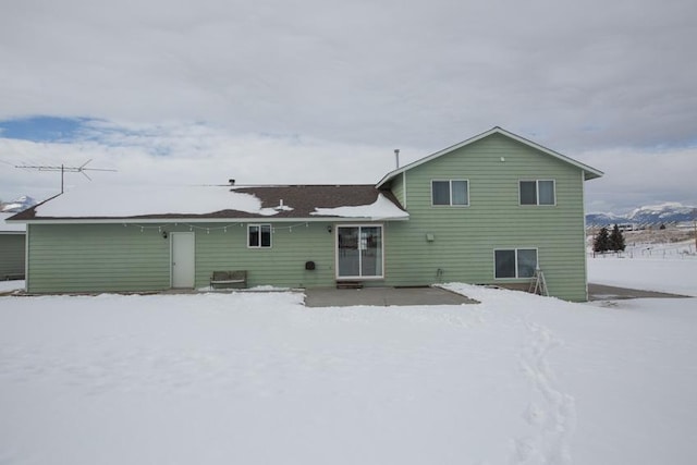 view of snow covered rear of property