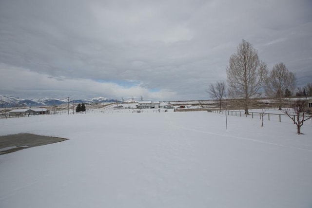 yard covered in snow featuring a mountain view