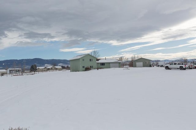 yard covered in snow with a mountain view