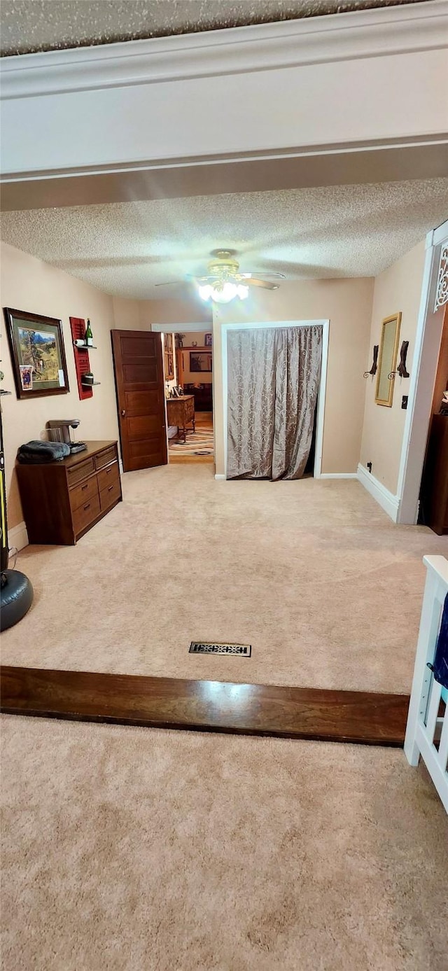 carpeted bedroom with a textured ceiling and ceiling fan