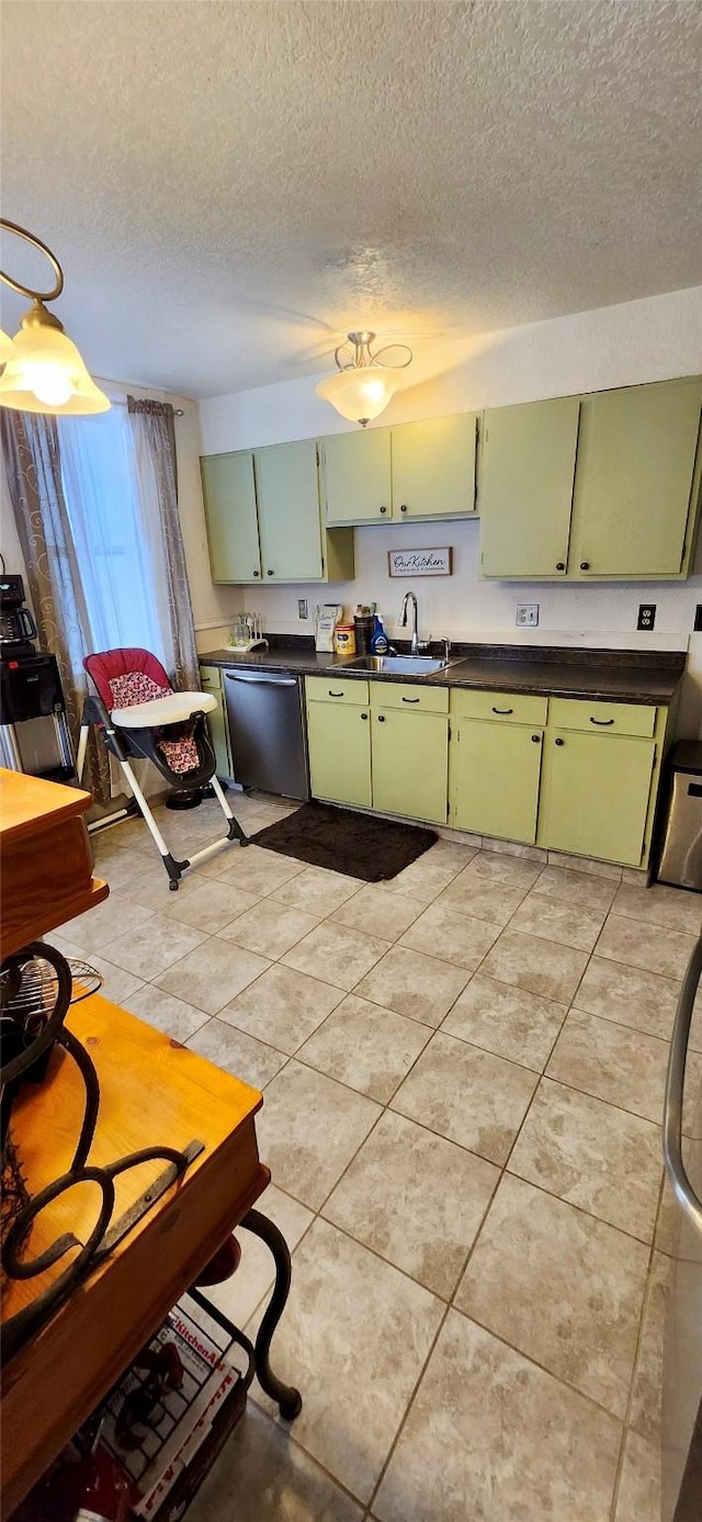 kitchen with green cabinets, dishwasher, sink, light tile patterned flooring, and a textured ceiling