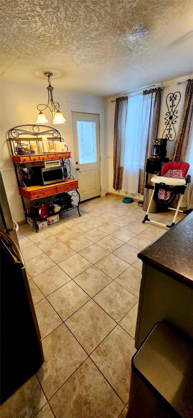 interior space featuring light tile patterned flooring and a textured ceiling