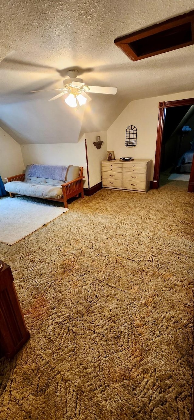 bedroom with ceiling fan, a textured ceiling, vaulted ceiling, and carpet floors