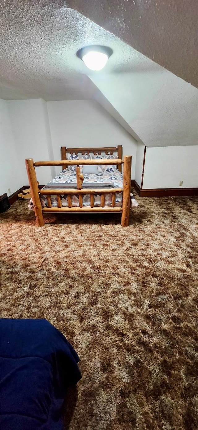 bedroom featuring carpet floors, a textured ceiling, and lofted ceiling