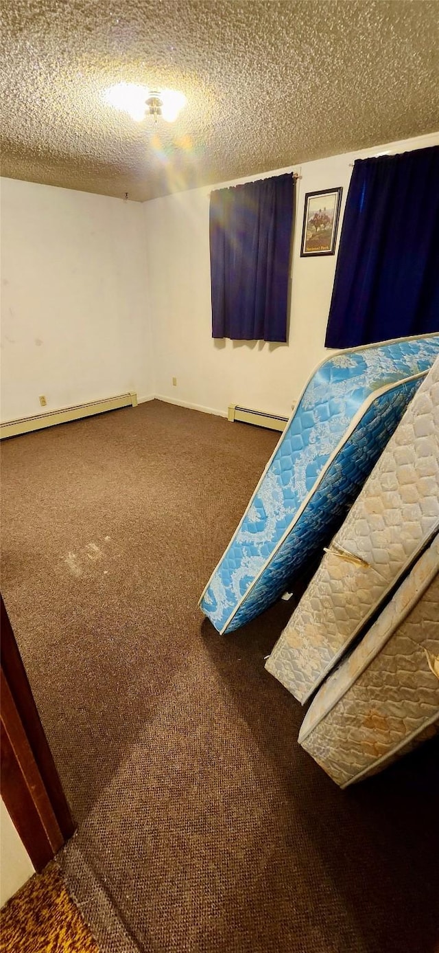 unfurnished bedroom featuring a textured ceiling, baseboard heating, and carpet floors