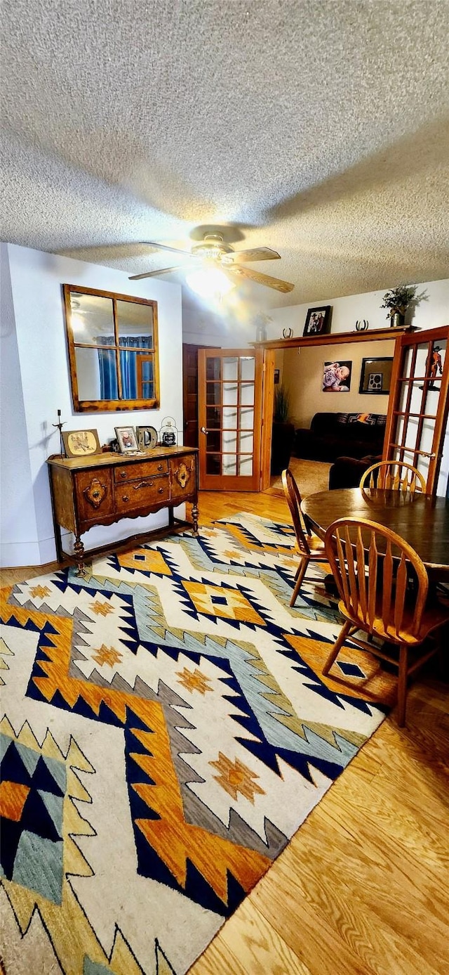 interior space featuring ceiling fan, light hardwood / wood-style floors, and a textured ceiling