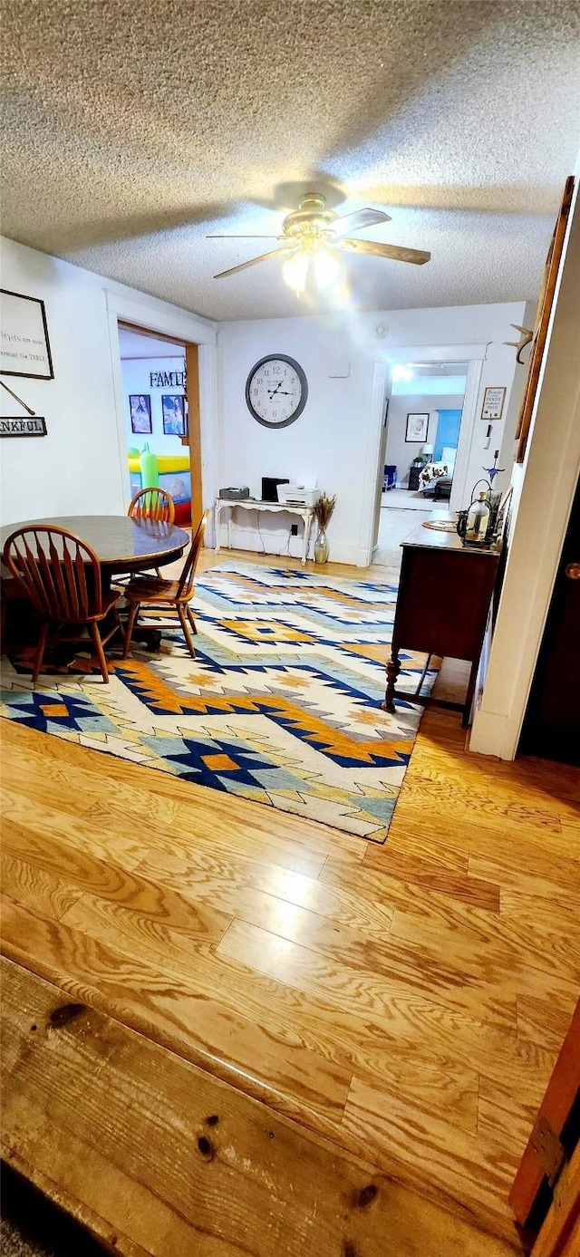 hallway with hardwood / wood-style floors and a textured ceiling